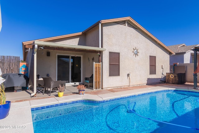 rear view of house featuring a patio area and a fenced in pool