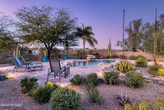 pool at dusk featuring a patio area