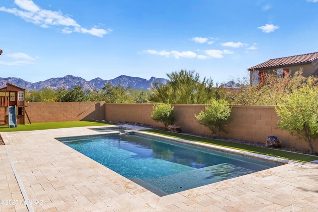 view of swimming pool with a mountain view, a playground, and an in ground hot tub