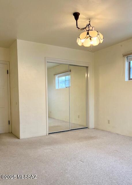 unfurnished bedroom featuring a closet, a notable chandelier, and wood-type flooring