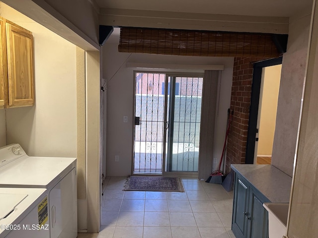 laundry area with light tile patterned floors, separate washer and dryer, and cabinets