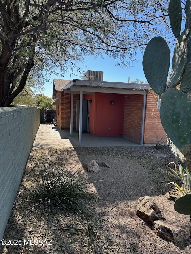 rear view of property featuring a patio and central AC