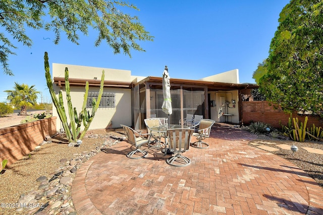 rear view of property with a patio and a sunroom