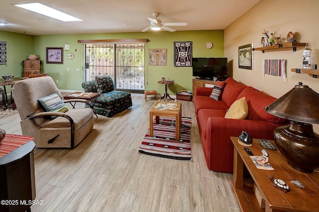 living room with ceiling fan and light hardwood / wood-style flooring