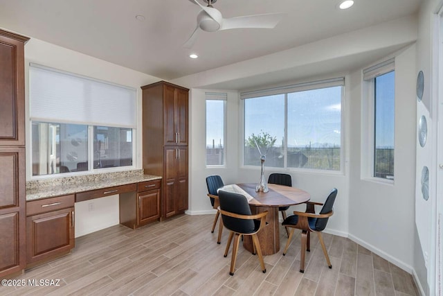 dining room featuring baseboards, recessed lighting, built in study area, and wood tiled floor