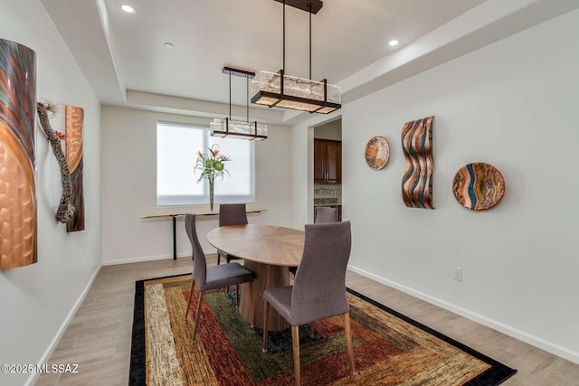 dining space featuring light wood finished floors, recessed lighting, and baseboards