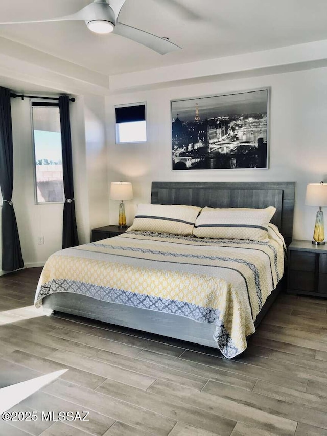 bedroom with multiple windows and wood finished floors