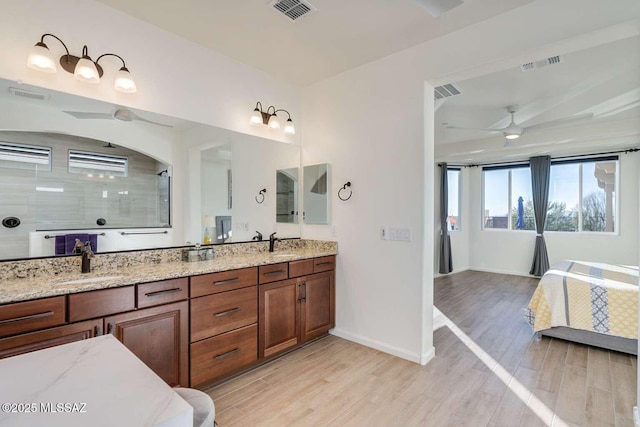 bathroom with wood finished floors, a sink, and visible vents