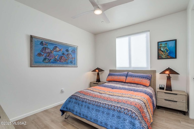 bedroom with a ceiling fan, baseboards, and wood finished floors