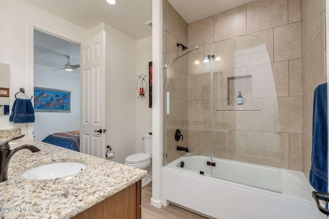 bathroom with shower / bath combination, toilet, wood finished floors, and vanity