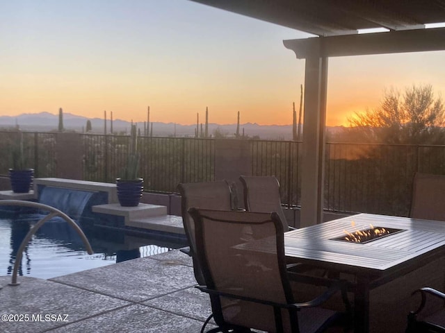 view of pool with a fire pit, a patio, fence, and a mountain view