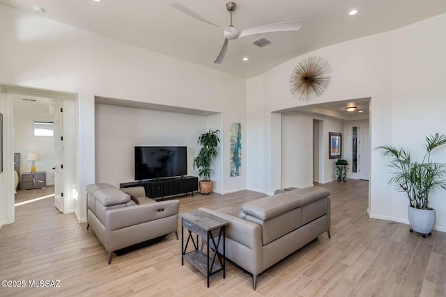 living area with recessed lighting, visible vents, a ceiling fan, light wood-type flooring, and baseboards