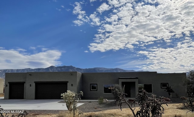 pueblo-style home featuring a mountain view and a garage