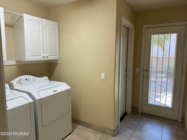 clothes washing area featuring washing machine and dryer and cabinets