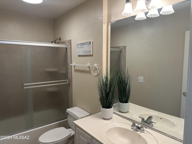 full bathroom featuring shower / bath combination with glass door, vanity, and toilet