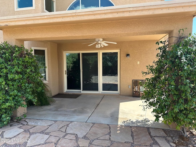 entrance to property with ceiling fan and a patio