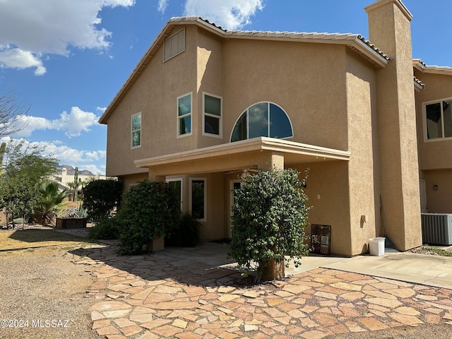 rear view of property featuring central air condition unit and a patio