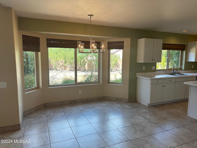 kitchen with a chandelier, decorative light fixtures, white cabinetry, and sink