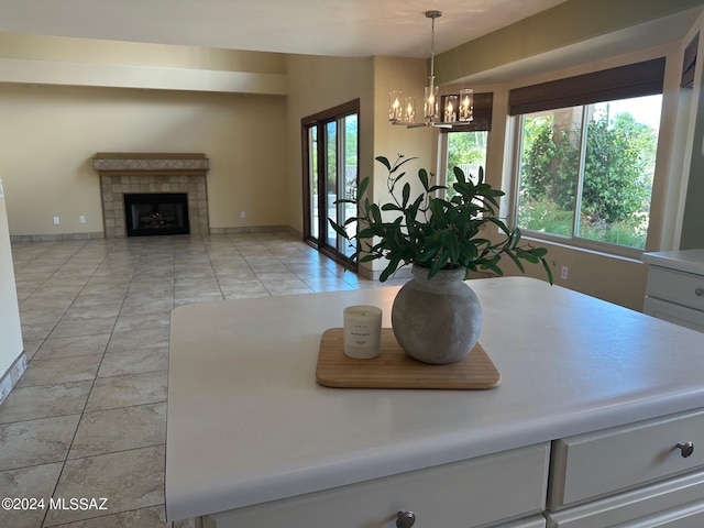 interior space featuring a chandelier, a fireplace, light tile patterned flooring, and pendant lighting