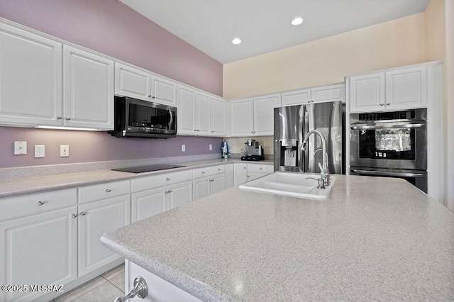 kitchen featuring light tile patterned floors, sink, white cabinetry, and appliances with stainless steel finishes