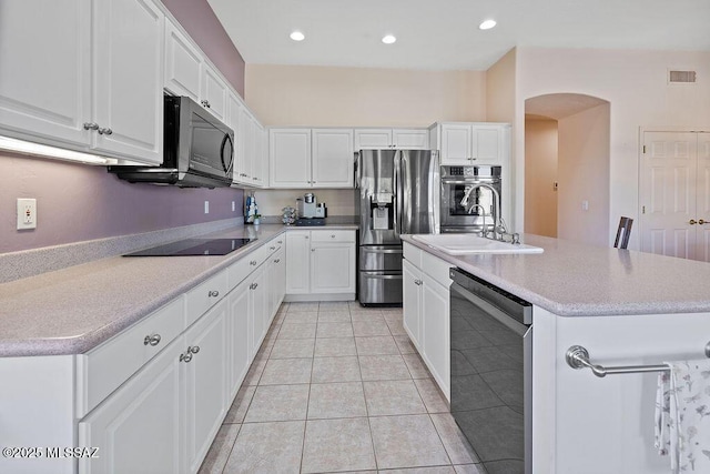 kitchen featuring white cabinets, stainless steel appliances, a kitchen island with sink, and sink