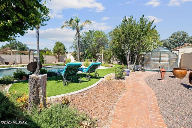 view of yard featuring a fenced in pool and an outdoor structure