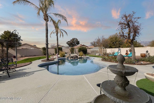 pool at dusk featuring a patio area