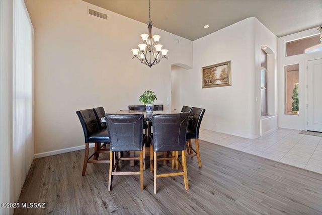 tiled dining room with a chandelier