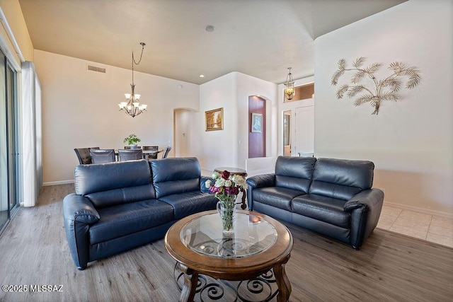 living room with wood-type flooring and a notable chandelier