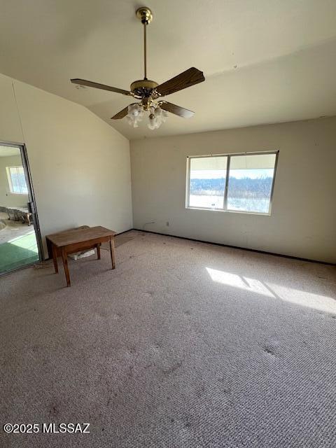 carpeted spare room featuring ceiling fan and lofted ceiling