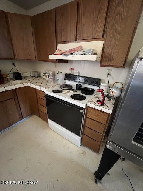 kitchen featuring white electric range oven and tile counters