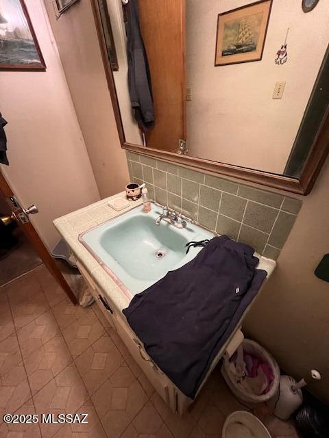 bathroom with tile patterned flooring, backsplash, and sink