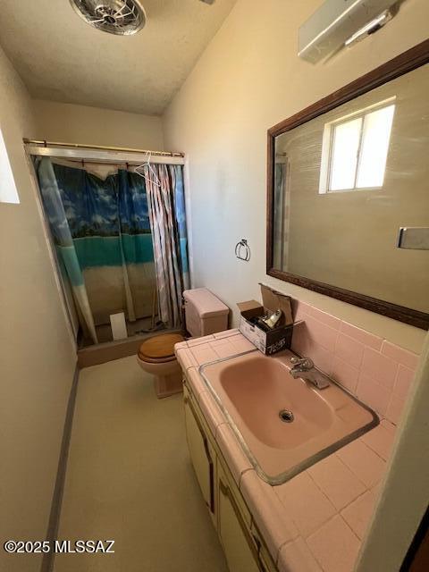 bathroom with toilet, a shower with shower curtain, and vanity