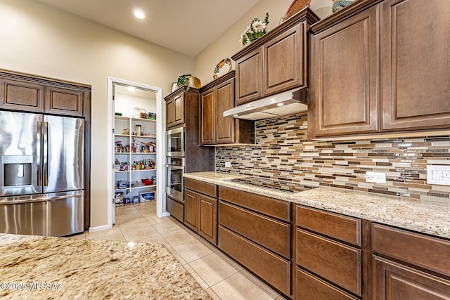 kitchen with tasteful backsplash, light tile patterned floors, light stone counters, and stainless steel appliances