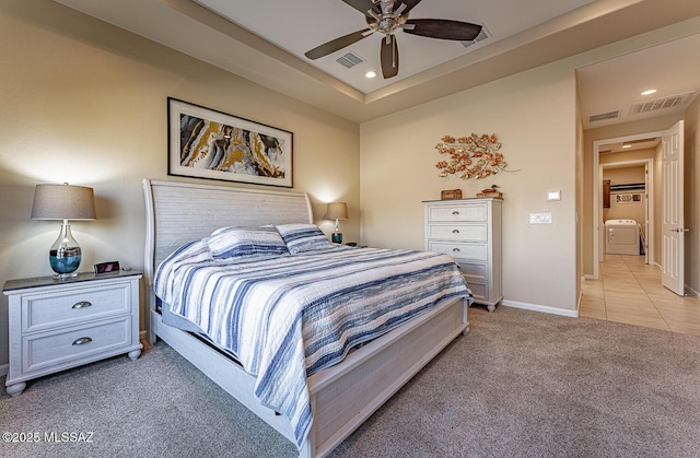 bedroom with ceiling fan, washer / dryer, and light carpet