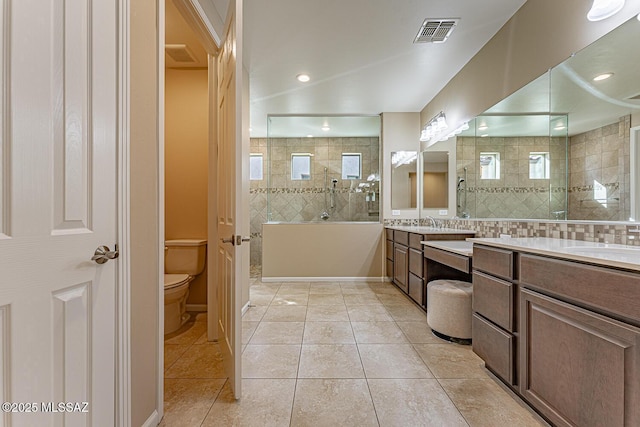 bathroom featuring a wealth of natural light, vanity, tiled shower, and tile patterned floors