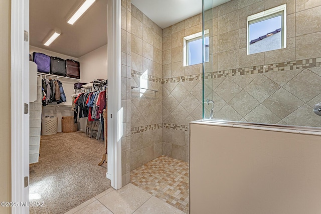 bathroom featuring a tile shower and tile patterned flooring