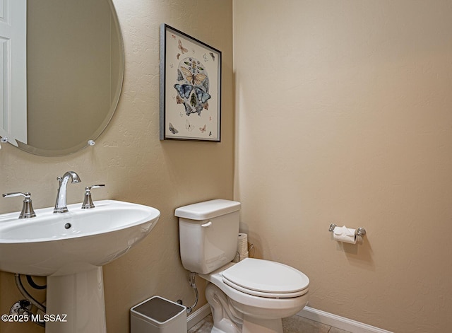 bathroom with sink, tile patterned flooring, and toilet