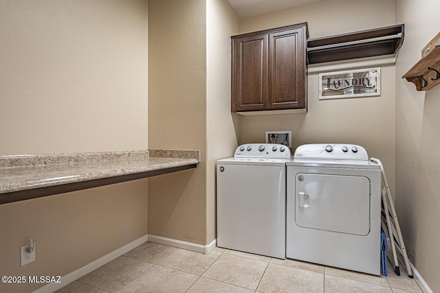 laundry area with cabinets, light tile patterned floors, and separate washer and dryer