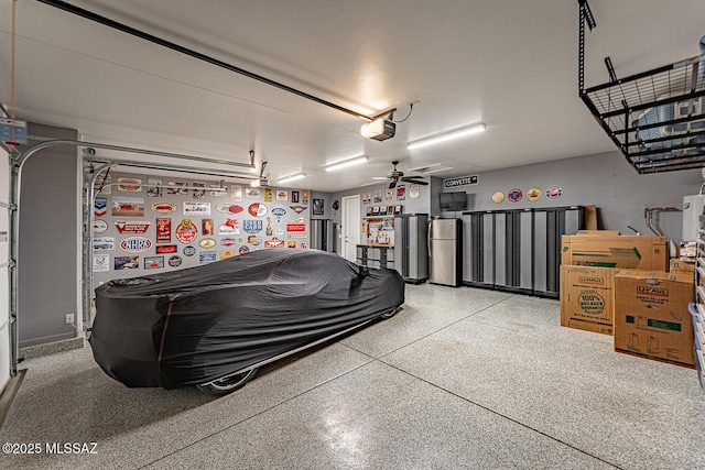 garage featuring a garage door opener, stainless steel fridge, and ceiling fan