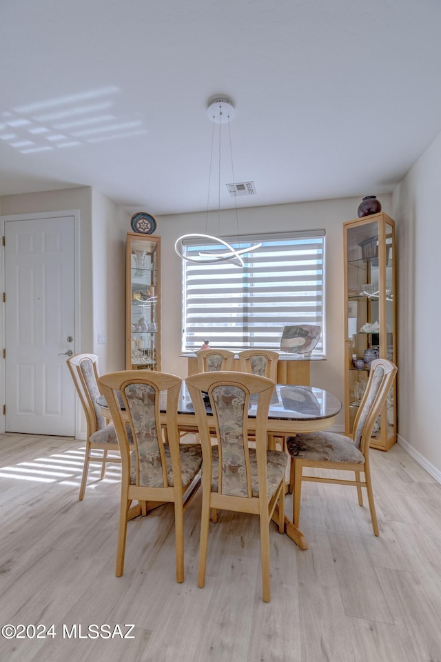 dining space featuring a wealth of natural light, visible vents, baseboards, and light wood-style floors