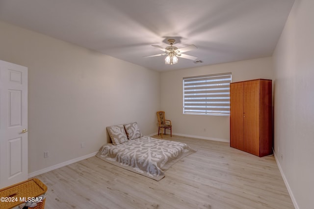 sitting room featuring light wood-style flooring, baseboards, and ceiling fan