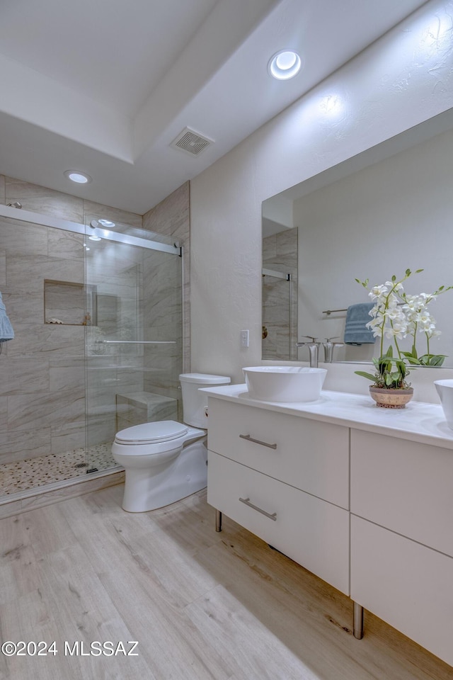 bathroom featuring visible vents, a stall shower, toilet, and vanity