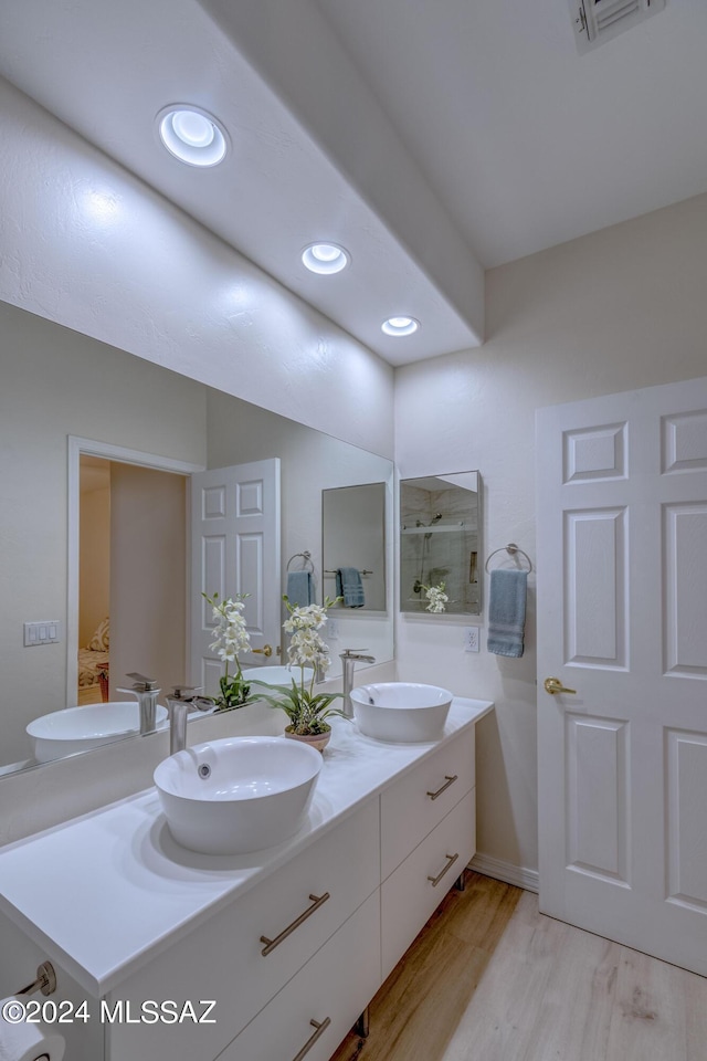 full bath featuring a sink, wood finished floors, and double vanity