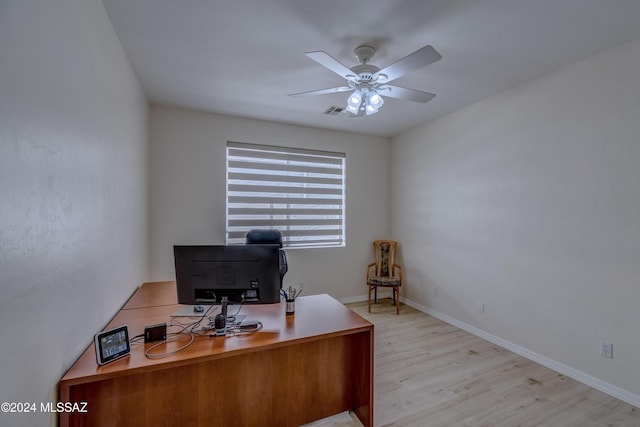 office area with baseboards, light wood-type flooring, and ceiling fan