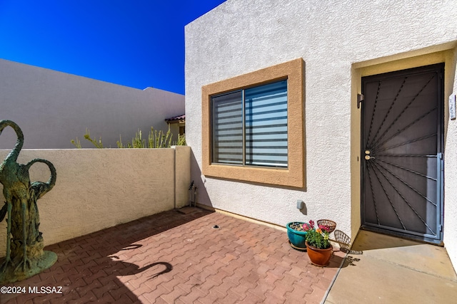 entrance to property with stucco siding and a patio area