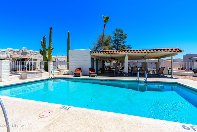 pool with a patio and fence