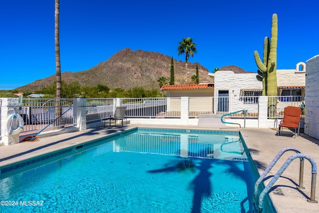 view of swimming pool with a mountain view, a patio area, a fenced in pool, and fence