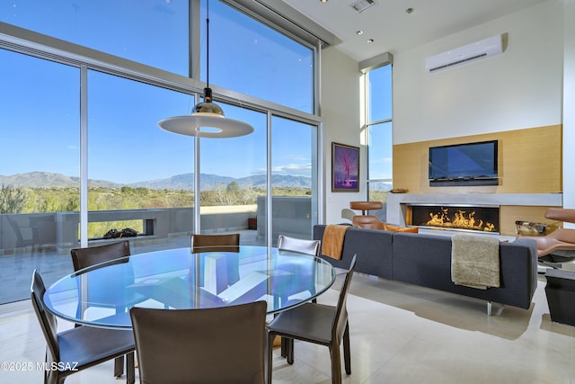 sunroom featuring a mountain view, plenty of natural light, and an AC wall unit