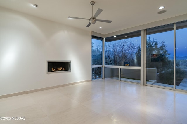 interior space featuring ceiling fan and a wall of windows